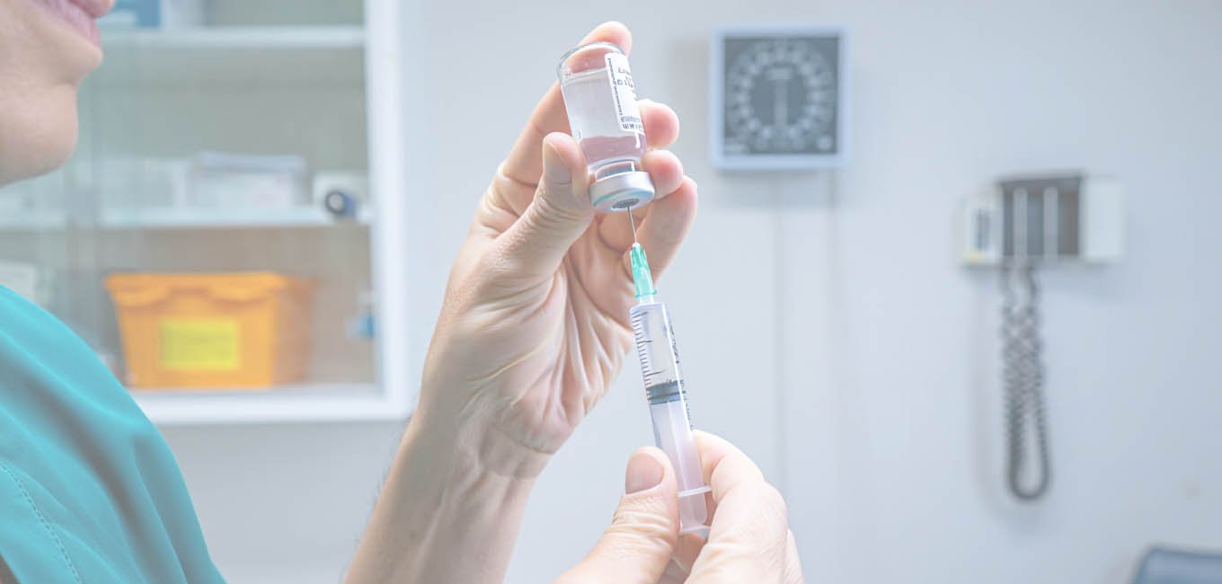 Медик-женщина готовит шприц к уколу